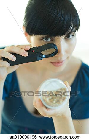 Woman looking at yogurt through magnifying glass View Large Photo Image Stock Photograph - Woman looking at yogurt through magnifying glass. Fotosearch