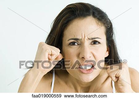 Stock Photo - Woman making angry face, holding up fists, portrait. Fotosearch