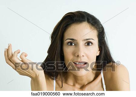 Stock Image - Woman making surprised face, holding up hand, portrait. Fotosearch