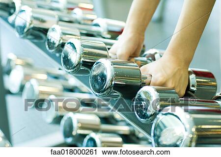 Woman picking up dumbbells View Large Photo Image Stock Image - Woman picking up dumbbells. Fotosearch