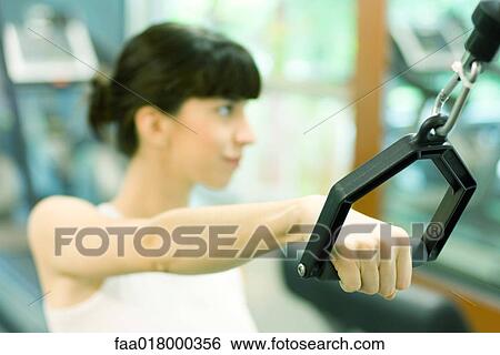 Woman pulling handle of exercise machine View Large Photo Image Stock Photograph - Woman pulling handle of exercise machine. Fotosearch