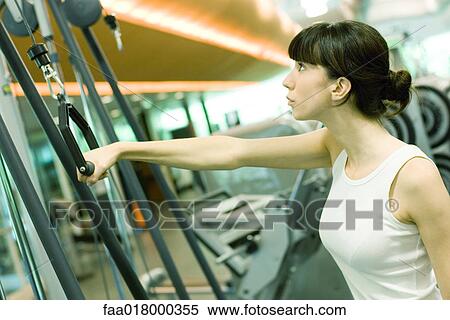 Woman pulling handle of exercise machine View Large Photo Image Stock Photography - Woman pulling handle of exercise machine. Fotosearch