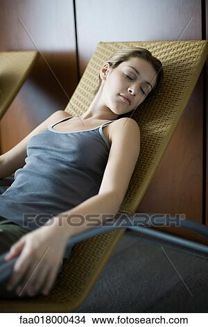 Woman relaxing on lounge chair, eyes closed View Large Photo Image Picture - Woman relaxing on lounge chair, eyes closed. Fotosearch