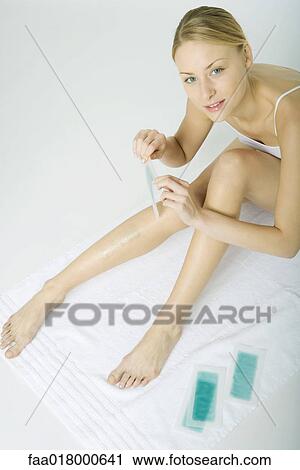 Stock Image - Woman removing cold wax strips. Fotosearch