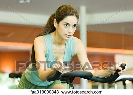 Woman riding exercise bike View Large Photo Image Stock Image - Woman riding exercise bike. Fotosearch