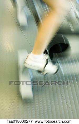 Stock Photo - Woman riding exercise bike. Fotosearch