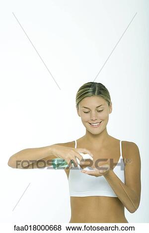 Stock Photo - Woman squeezing beauty product into palm of hand. Fotosearch