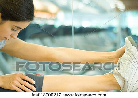 Stock Photo - Woman stretching leg on barre. Fotosearch