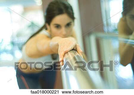 Stock Image - Woman stretching on barre. Fotosearch