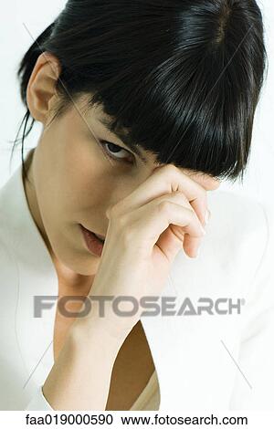 Woman touching bridge of nose, looking at camera View Large Photo Image Stock Image - Woman touching bridge of nose, looking at camera. Fotosearch
