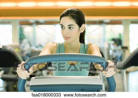 Stock Image - Woman using exercise machine. Fotosearch