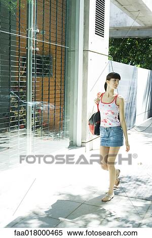 Woman walking down sidewalk, full length View Large Photo Image Stock Photography - Woman walking down sidewalk, full length. Fotosearch