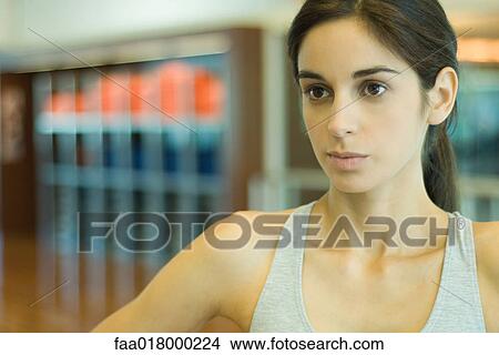 Woman wearing sports clothing, looking away, portrait View Large Photo Image Picture - Woman wearing sports clothing, looking away, portrait. Fotosearch