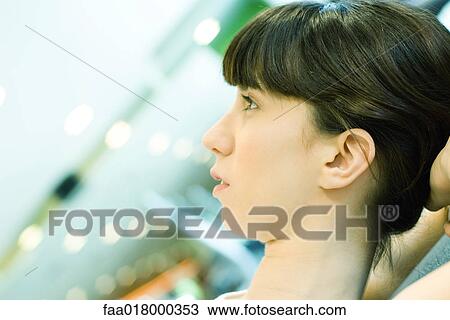Stock Image - Woman with hands behind head, doing sit-ups, close-up of head. Fotosearch