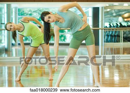 Stock Photo - Women doing standing side bend. Fotosearch