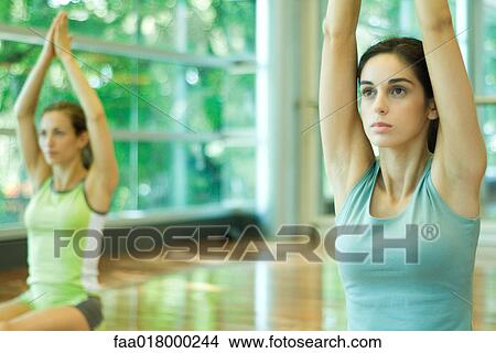 Picture - Women kneeling with arms raised overhead. Fotosearch