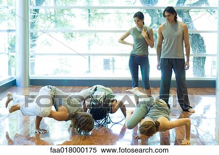 Young adults doing crow pose in yoga class View Large Photo Image Stock Photography - Young adults doing crow pose in yoga class. Fotosearch