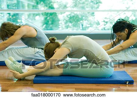Young adults doing seated forward bend in exercise class View Large Photo Image Stock Image - Young adults doing seated forward bend in exercise class. Fotosearch