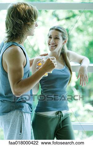Young couple in exercise clothing standing by window View Large Photo Image Stock Image - Young couple in exercise clothing standing by window. Fotosearch