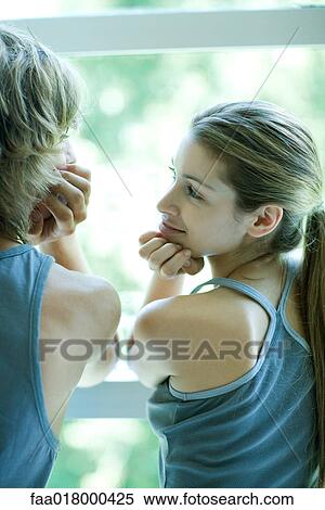 Young couple in exercise clothing standing by window, looking at each other View Large Photo Image Stock Photography - Young couple in exercise clothing standing by window, looking at each other. Fotosearch