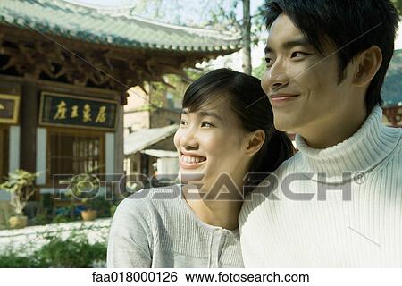 Young couple looking away, smiling, portrait View Large Photo Image Stock Photograph - Young couple looking away, smiling, portrait. Fotosearch