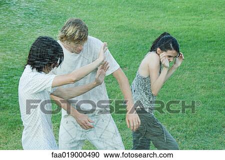 Young friends getting wet View Large Photo Image Stock Image - Young friends getting wet. Fotosearch