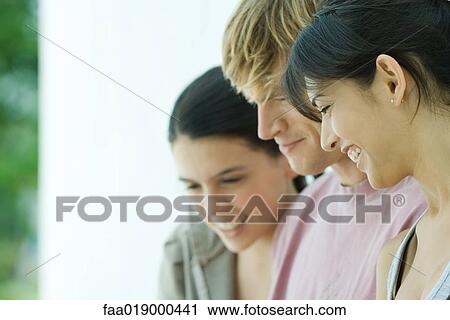 Young friends, looking down, close-up View Large Photo Image Stock Image - Young friends, looking down, close-up . Fotosearch