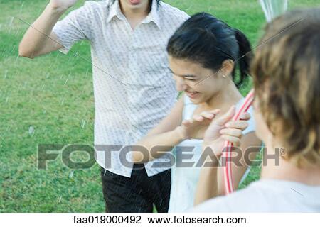 Young friends playing with garden hose, blurred motion View Large Photo Image Stock Image - Young friends playing with garden hose, blurred motion. Fotosearch