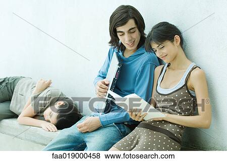 Young friends reading book together View Large Photo Image Stock Photo - Young friends reading book together. Fotosearch