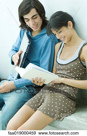 Young friends reading book together View Large Photo Image Stock Photo - Young friends reading book together. Fotosearch