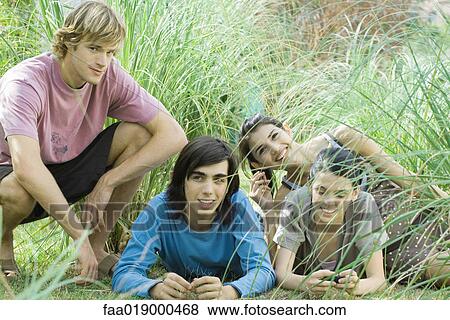 Young friends reclining in grass View Large Photo Image Stock Photo - Young friends reclining in grass. Fotosearch