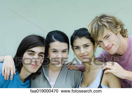 Stock Image - Young friends, smiling at camera, portrait. Fotosearch