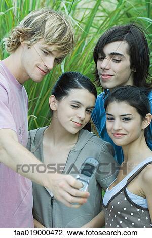 Young friends taking group photo with cell phone View Large Photo Image Stock Image - Young friends taking group photo with cell phone. Fotosearch