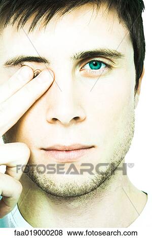 Young man covering eye, looking at camera, extreme close-up View Large Photo Image Stock Photo - Young man covering eye, looking at camera, extreme close-up. Fotosearch