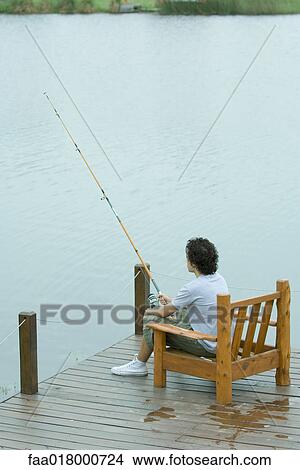 Young man fishing on dock View Large Photo Image Picture - Young man fishing on dock. Fotosearch