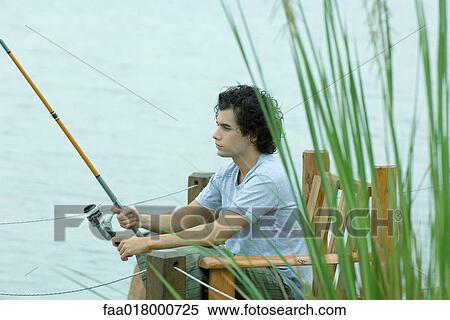 Stock Photography - Young man fishing on dock. Fotosearch