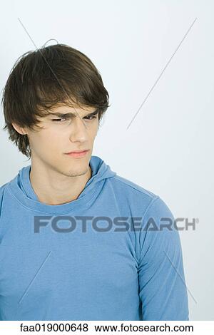 Young man furrowing brow, portrait View Large Photo Image Stock Photo - Young man furrowing brow, portrait. Fotosearch