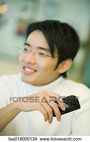 Young man holding cell phone View Large Photo Image Picture - Young man holding cell phone. Fotosearch