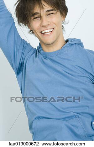 Young man jumping and smiling, portrait View Large Photo Image Stock Image - Young man jumping and smiling, portrait. Fotosearch