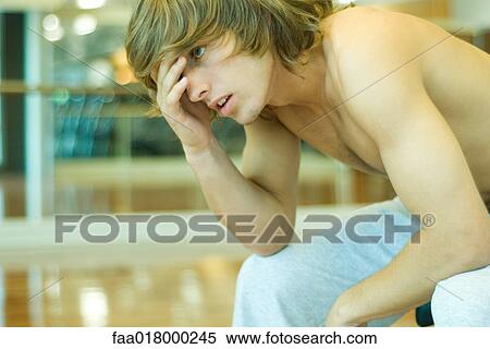 Young man leaning forward, covering face View Large Photo Image Stock Photography - Young man leaning forward, covering face. Fotosearch