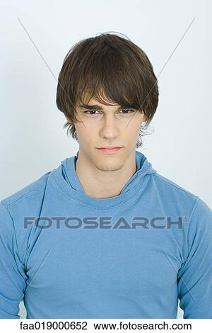 Stock Image - Young man looking at camera, portrait. Fotosearch