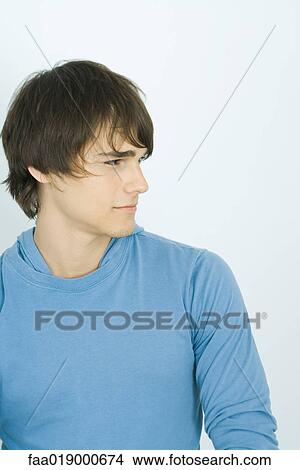 Young man looking away, portrait View Large Photo Image Picture - Young man looking away, portrait. Fotosearch