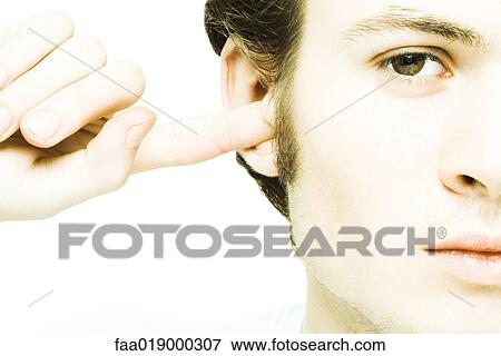 Young man plugging ear with finger View Large Photo Image Stock Photo - Young man plugging ear with finger. Fotosearch