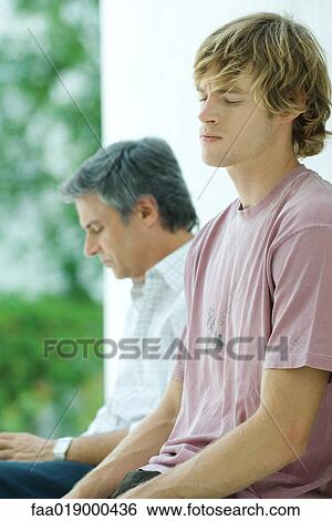 Young man sitting near father, eyes closed View Large Photo Image Stock Photograph - Young man sitting near father, eyes closed. Fotosearch