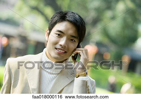 Young man using cell phone, portrait View Large Photo Image Stock Photograph - Young man using cell phone, portrait. Fotosearch