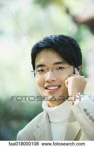 Young man using cell phone View Large Photo Image Stock Photo - Young man using cell phone. Fotosearch