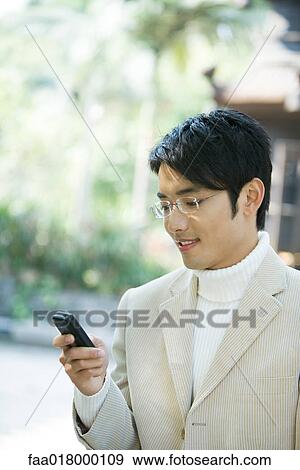 Young man using cell phone View Large Photo Image Stock Photo - Young man using cell phone. Fotosearch