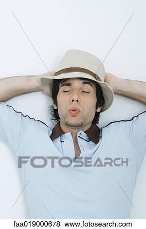 Young man wearing hat, eyes closed, whistling View Large Photo Image Stock Photo - Young man wearing hat, eyes closed, whistling. Fotosearch