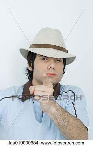 Young man wearing hat, pointing at camera View Large Photo Image Picture - Young man wearing hat, pointing at camera. Fotosearch