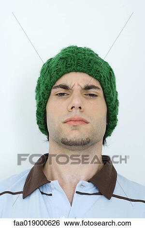 Young man wearing knit hat, furrowing brow, portrait, close-up View Large Photo Image Stock Photograph - Young man wearing knit hat, furrowing brow, portrait, close-up. Fotosearch